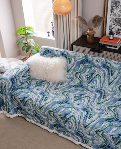 Close-up of jacquard woven sofa cover with blue marble pattern and white fringe edge