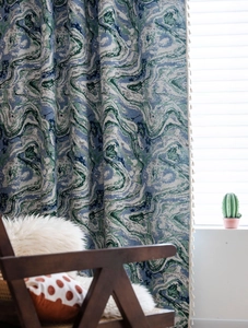 Detail of marble pattern curtain fabric in blue and green with off-white side tassels