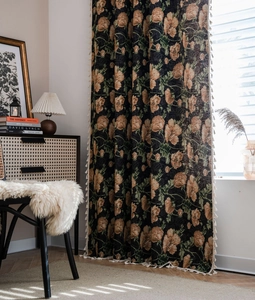 Close-up of retro floral jacquard curtain with orange blooms and cream tassel fringe