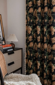 Close-up of vintage black floral jacquard curtain with brown flowers and white tassels