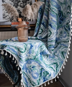 Detail of woven tapestry with blue marble pattern and white tassel fringe edges