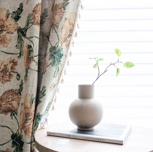 Detailansicht beige Blumenvorhang mit Jacquard-Muster und eleganter Keramikvase Textur