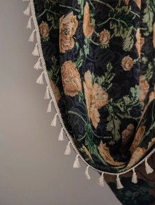 Detail of floral jacquard fabric showing vintage patterns and beige tassel fringe edges