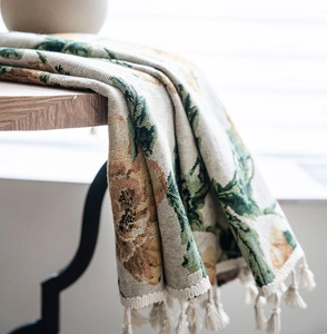 Detailansicht von floralem Jacquard-Stoff mit Blattmustern und eleganten Quasten