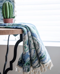 Detail of woven jacquard fabric with blue floral patterns and elegant white fringe trim