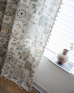 Detail view of bohemian cotton linen curtain with blue mandala pattern and tassels