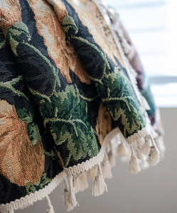 Detail of floral jacquard curtain showing intricate sunflower patterns and cream tassels