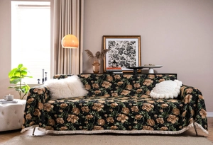 Detail of floral jacquard sofa cover with thick woven texture and white fringe trim