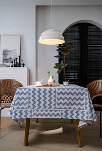 Detail of blue zigzag geometric pattern on rectangular linen tablecloth over wood table