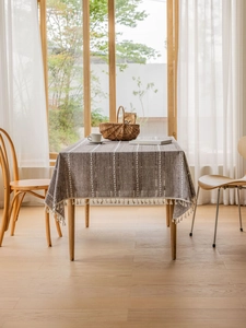 Close-up of dark brown cotton linen tablecloth with white stripes and tassel fringe