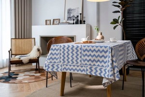 Detail showing blue geometric wave patterns on a beige rectangular cotton linen tablecloth