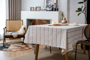 Detail of modern striped linen tablecloth showing fabric texture in a cozy dining room