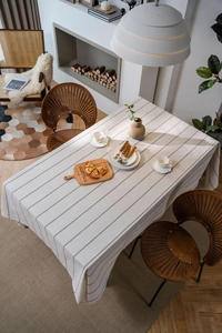 Detail of striped cotton linen tablecloth showing elegant fabric drape on a dining table