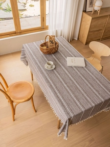 Close-up of coffee brown striped cotton linen tablecloth with handmade fringe details