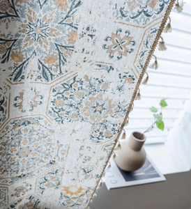 Detail of bohemian printed curtain with mandala pattern and rustic cotton linen tassels