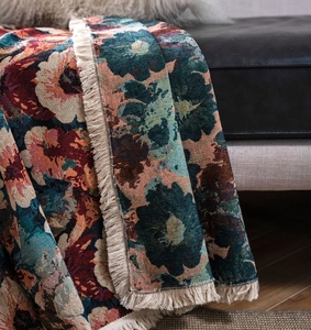 Close-up of vintage floral jacquard sofa throw with fringe details in bohemian style