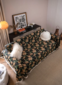 Close-up of floral jacquard sofa cover with fringe detail and American retro pattern