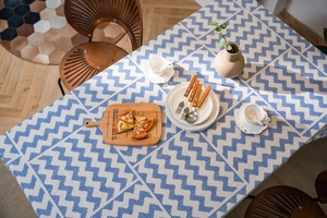 Detail of blue and white geometric wave pattern linen tablecloth on a dining table