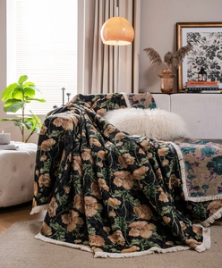 Detail of vintage floral jacquard throw blanket with elegant white tassel fringe