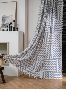 Détail des rideaux en lin bohème avec motif géométrique bleu à vagues et franges