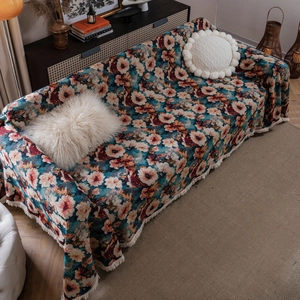 Vintage floral jacquard sofa throw cover with beige tassels in a cozy home setting