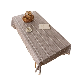 Brown and white striped linen tablecloth with decorative tassels and geometric patterns