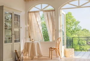 French retro beige lace curtain with floral embroidery on arched window detail