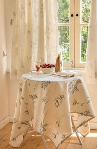 Detail of white lace trim on grey floral pattern cotton linen curtains and tablecloth