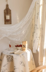 Close-up of vintage floral curtains with elegant lace embroidery and matching tablecloth