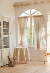 Detailed close-up of French style cream lace curtain with floral embroidery and wavy edges