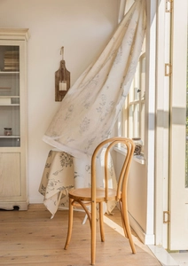 Detail showing elegant grey floral print on light beige cotton linen fabric with natural light