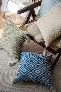 Detail of woven geometric throw pillows featuring diamond patterns and corner tassels