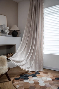 Detail of cream linen curtain with white embroidery stripes and decorative tassels