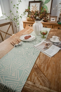 Close-up of mint green geometric triangle pattern and texture on cotton linen table runner