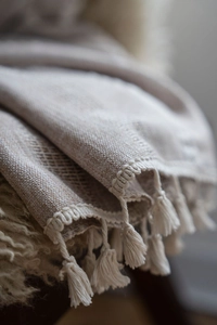 Detail of coffee striped embroidered curtain fabric with elegant tassel fringe and texture