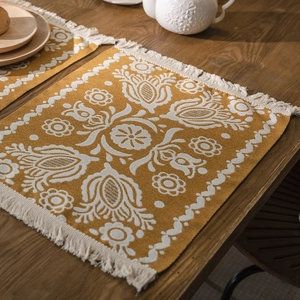 Bohemian jacquard table runner with yellow floral patterns and white tassels on wood