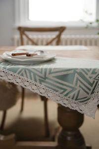 Close-up of geometric table runner featuring white lace border and mint green fabric texture