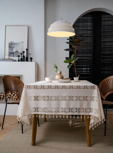Detailed view of hollow crochet tablecloth with geometric diamond patterns and mini tassels