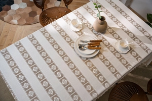 Close-up of cream rectangle tablecloth with geometric crochet hollow and tassels