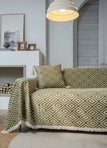 Detail of green and white geometric jacquard sofa cover fabric with fringe tassels
