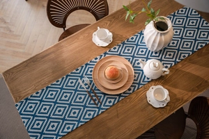 Close-up of geometric blue and white jacquard table runner on a wooden dining table