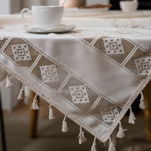 Rectangular cream crochet tablecloth with hollow grid pattern and tassel edges