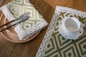 Close-up of bohemian orange geometric jacquard table runner with delicate lace edges