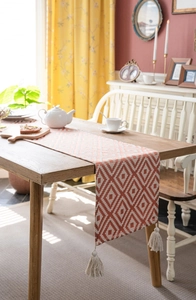 Detailed view of bohemian table runner with geometric diamond patterns and tassel fringe