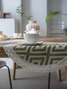 Close-up of geometric wave patterns on woven table runner with crochet lace edges