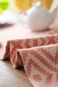 Close-up of orange geometric zigzag woven table runner with thick cotton fabric texture
