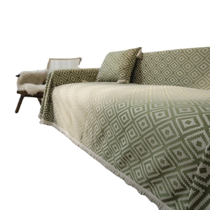 Green and cream geometric jacquard throw blanket with decorative tassels and matching pillow