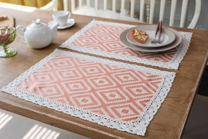 Detail of geometric orange table runner with lace border and jacquard fabric texture