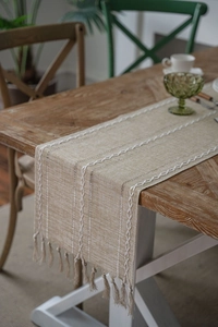 Detail of Nordic jacquard table runner featuring handmade tassels and openwork weaving texture