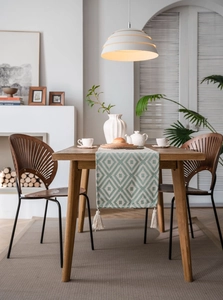 Detail of Nordic table runner featuring teal geometric jacquard patterns and cream tassels